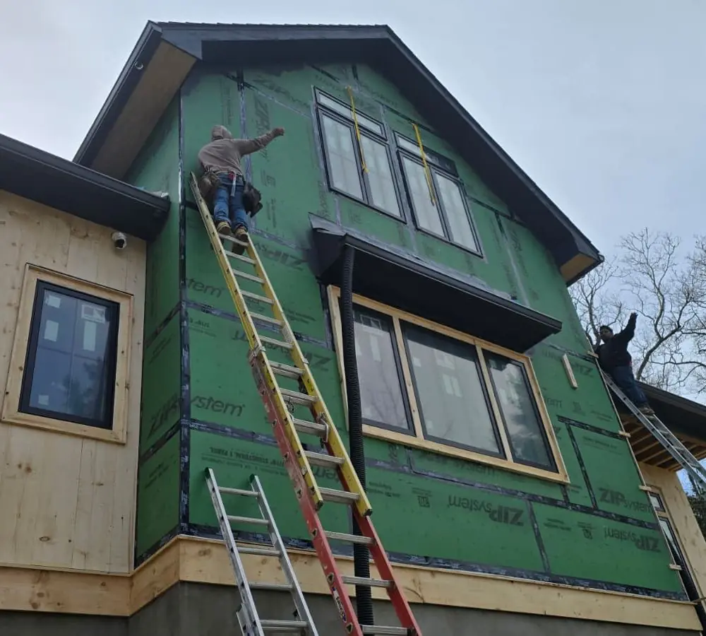 Bird Carpenter crew installing siding over a taped weather barrier